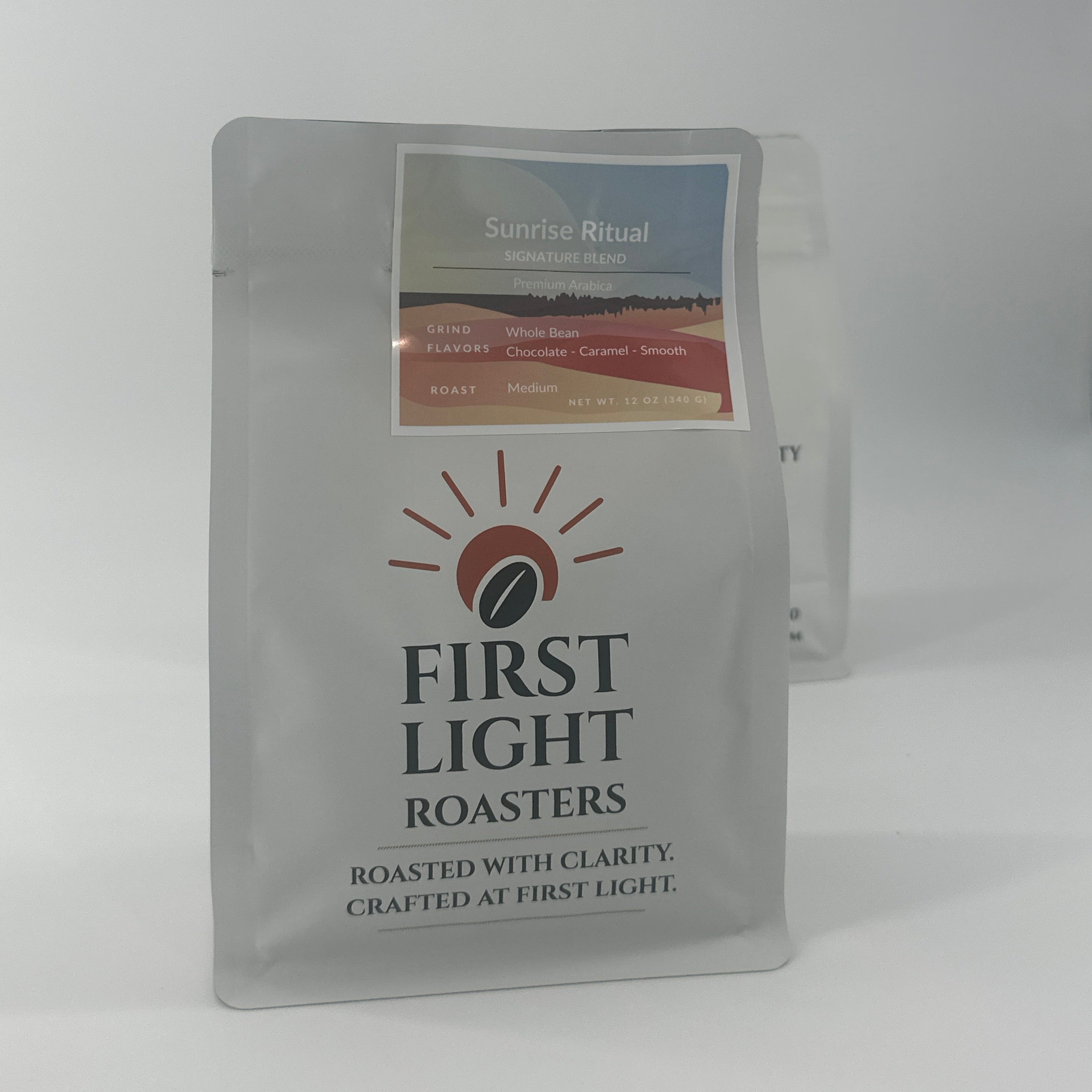 Two coffee packets from First Light Roasters on a white background