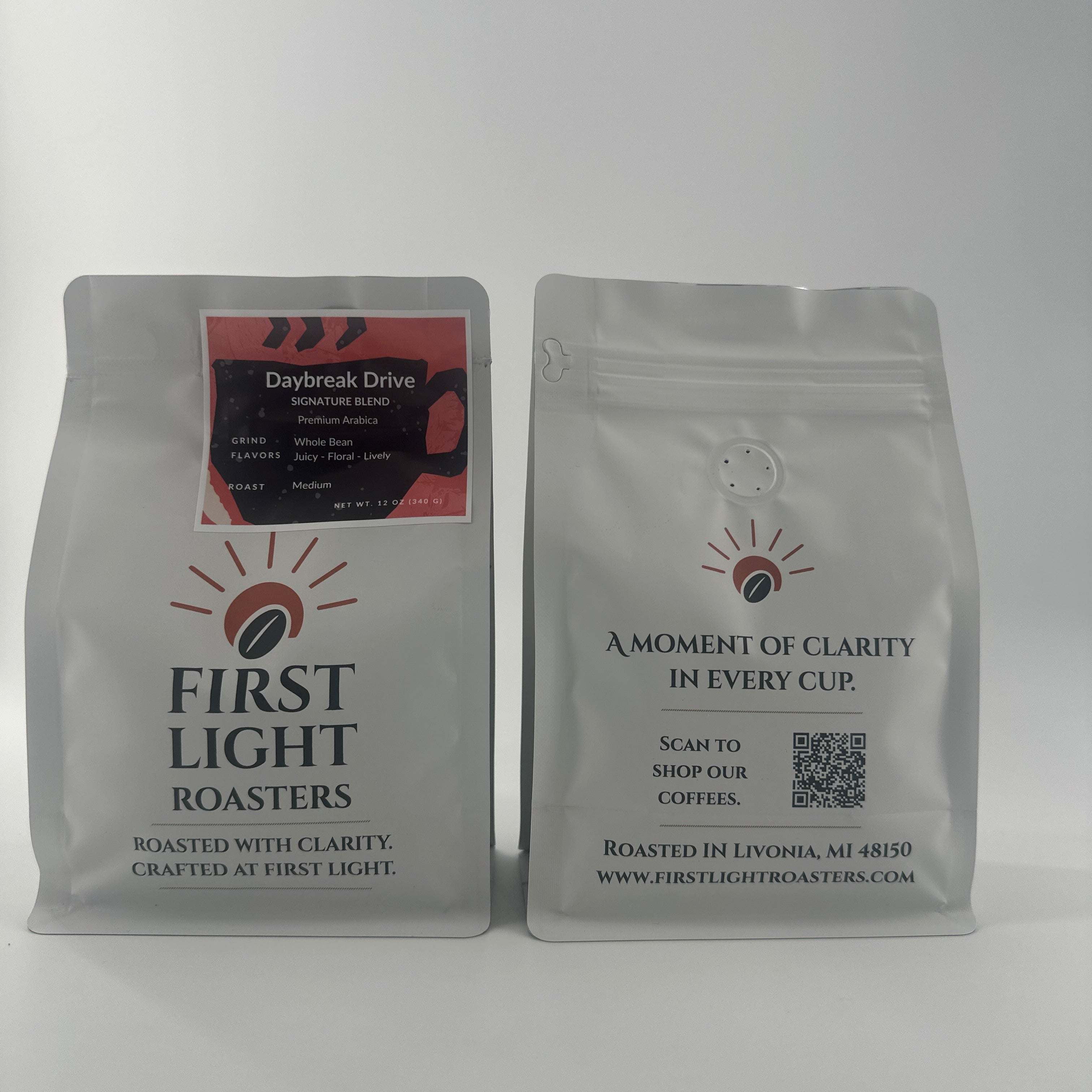 Two coffee bags from First Light Roasters on a white background