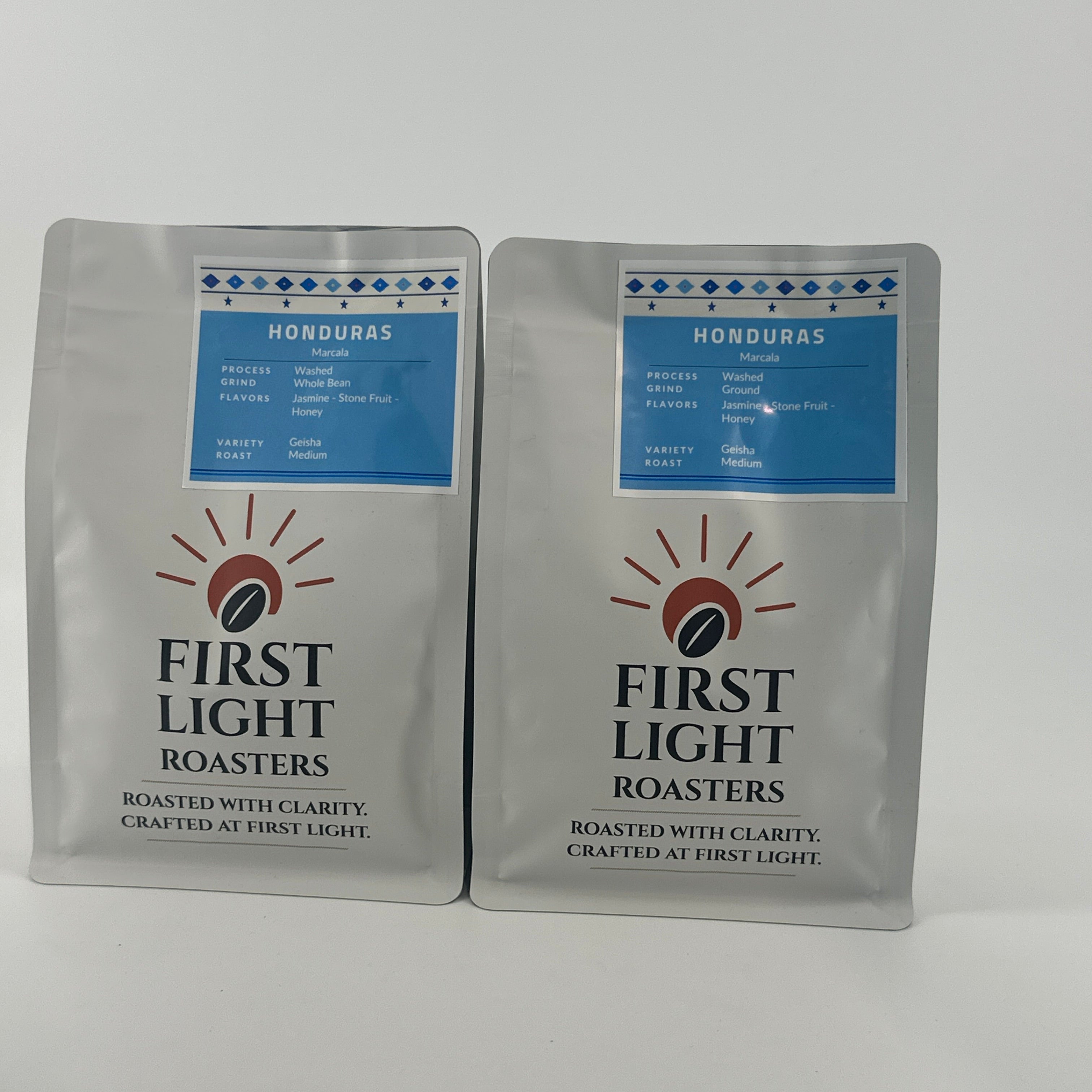 Two packages of First Light Roasters coffee on a white background