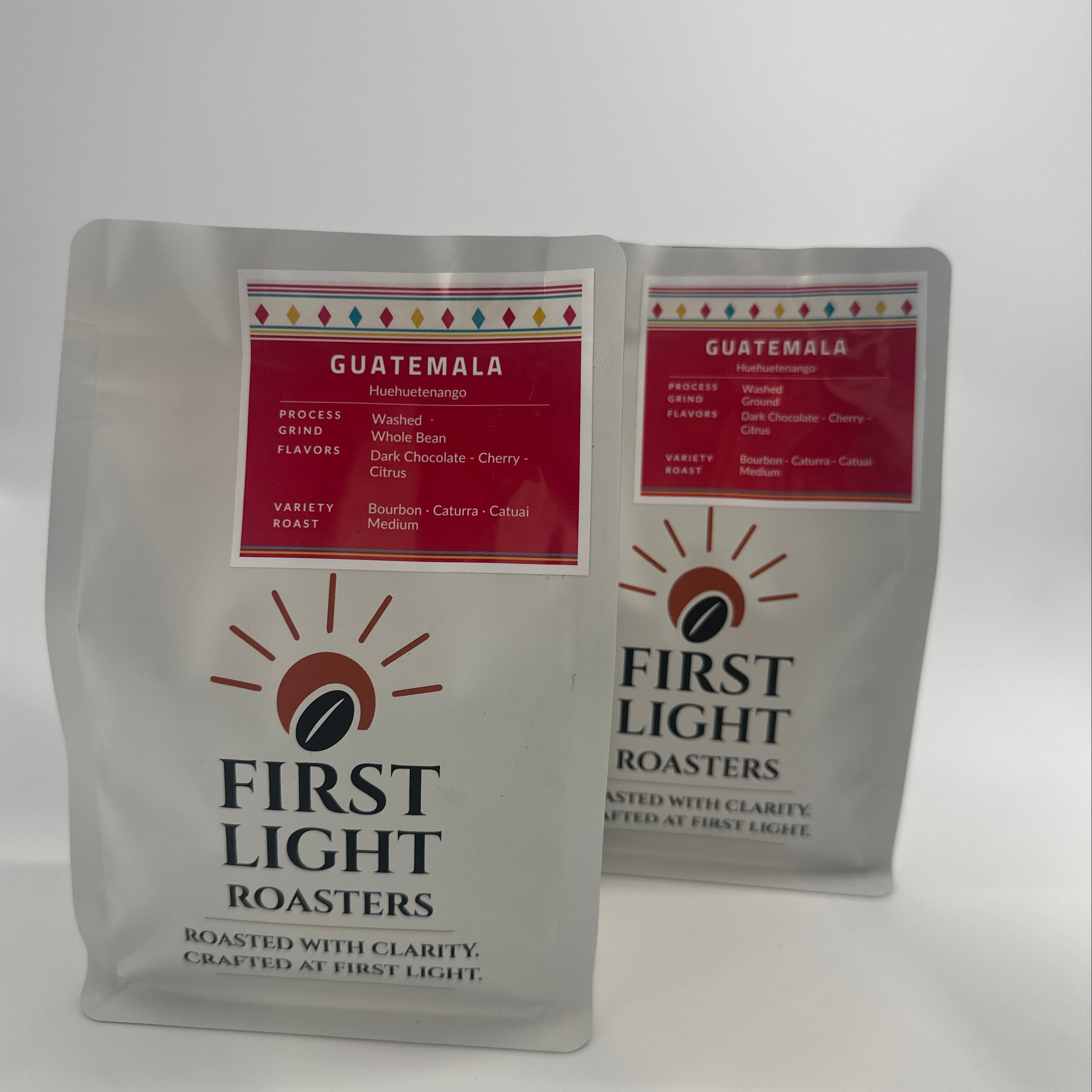 Two packages of First Light Roasters coffee on a white background