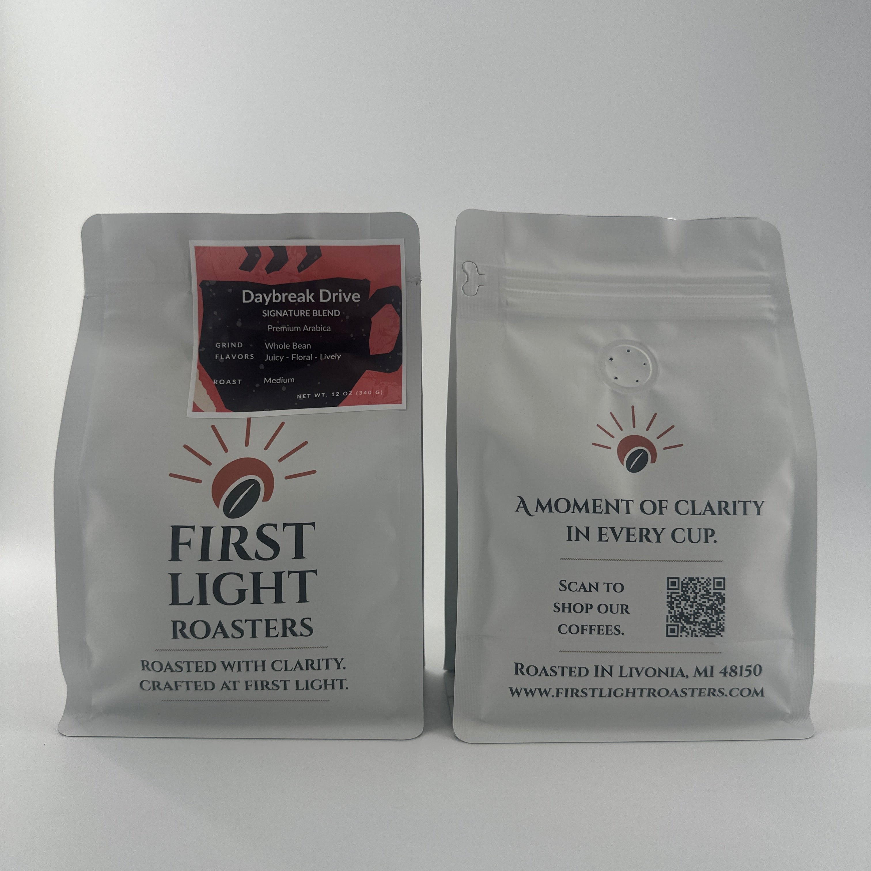 Two coffee bags from 'First Light Roasters' on a white background